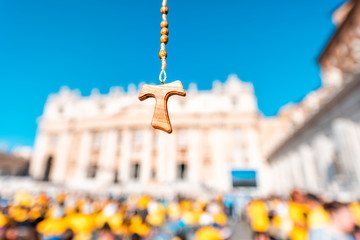 Closeup of wooden Italian cross Catholic rosary with bokeh blurry background of Vatican church St...
