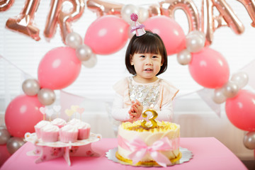 Fototapeta na wymiar toddler girl celebrating her third birthday at home