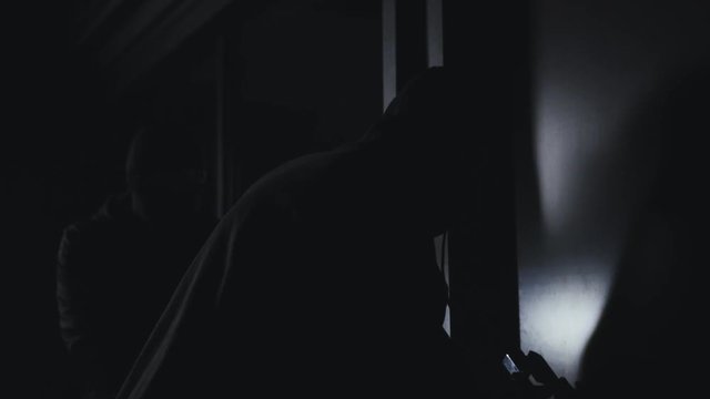 Burglars in balaclavas with guns and flashlights opening the doors, entering flat. Committing crime, villains entering private territory, criminals. Following partner in crime, no security system