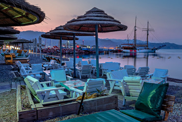 Night scene on central beach of Eilat with moored sail boats yachts and resting public tourist areas. Eilat is a famous tourist resort and recreational city in Israel