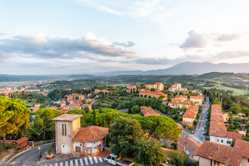 Fototapeta na wymiar Chiusi sunset evening in Umbria, Italy with rooftop houses on mountain countryside rolling hills and street road with colorful picturesque cityscape with clouds