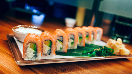 Sushi Philly plateau buffet in night dining restaurant flat lay. Delicious Philadelphia salmon flesh seaweed and ginger. Sushi rolls served on  plate in a restaurant. The norwegian salmon and Fish.