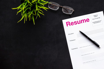 Create CV concept with pen, glasses on black desk top view copyspace