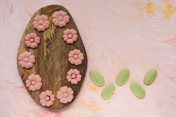 SPRING word and flower cookies on a wooden board on a pink background . Spring holidays cooking...