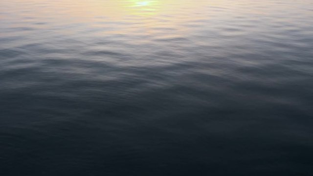 Marine picture. Blue sea water with a reflection of the sky on its surface of white volumetric clouds. Calm excitement on the sea surface on the sunset. Texture sea water with small waves. Copyspace