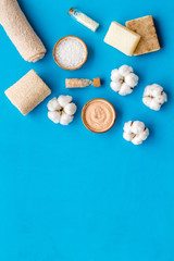 Spa set with eco materials for organic treatment on blue background top view space for text
