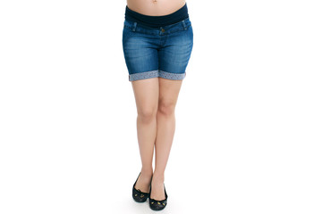 Pregnant woman in blue jeans shorts isolated white background
