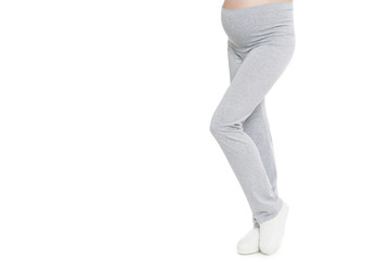 Pregnant woman legs in gray pants isolated white background