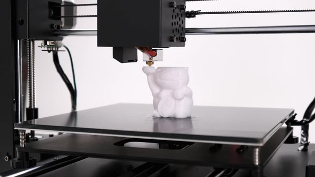 Printing on 3D printer cat toy figurines from white plastic close-up. Clear print head movements. The potential of modern technology 3D printing. Project visualization. Plastic reel on stand