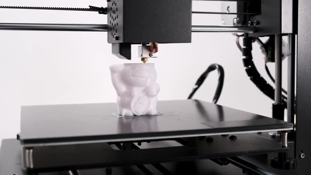 Printing on 3D printer cat toy figurines from white plastic close-up. Clear print head movements. The potential of modern technology 3D printing. Project visualization. Plastic reel on stand