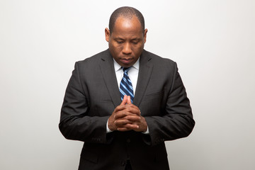 African Business Man Dressed in Suit Thinking On Light Gray Background