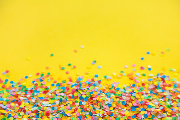 Frame made of colored confetti. Yellow background
