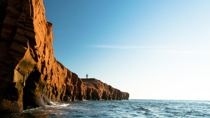 Fototapeta na wymiar Lighthouse Behind Red Cliffs