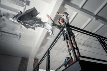 Emotional stressed woman throwing clothes of ex husband away