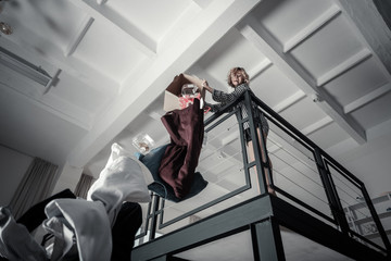 Emotional angry woman throwing clothes of ex husband away