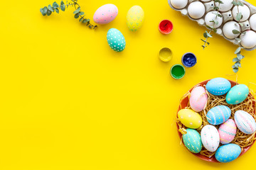 eggs with colorful paint for easter tradition on yellow background top view mockup