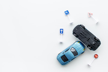 Car insurance concept with car toys on white background top view copyspace