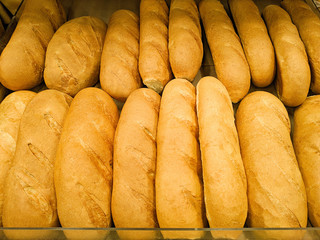 Crusty bread baguette in a bakery. Fresh organic pastry at a local market. Traditional France cuisine