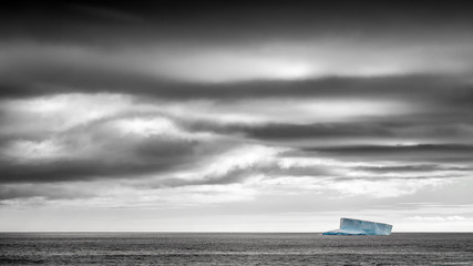Solitary iceberg in the Southern Ocean under stormy dramatic sky © James Stone