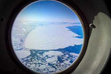 Sea ice and icebergs through porthole 