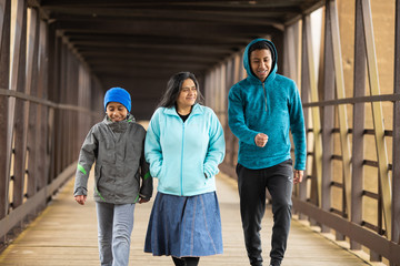 Hispanic Mother Walks With Sons On A Bridge