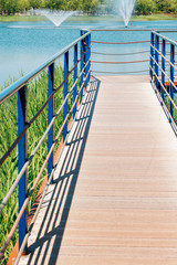 Blue lake and wooden deck walkway in Bucheon Sangdong Lake Park, Korea