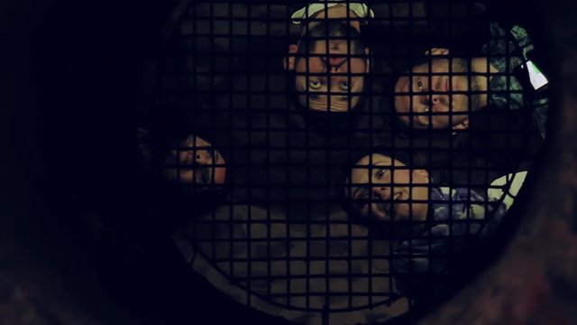Low angle shot of four talking young people through the bars. Cheerful mood, hanging out, having fun. Adventure time, quest room. True friendship, positive emotions