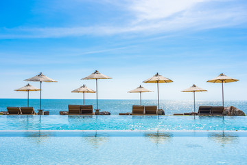 Beautiful landscape of sea ocean on sky with umbrella and chair around luxury outdoor swimming pool