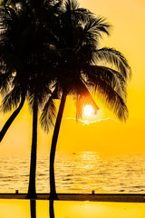 Beautiful Silhouette coconut palm tree on sky around swimming pool in hotel resort neary sea ocean beach at sunset or sunrise time