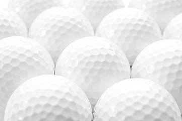 Brightly lit image of several golf balls creating a full frame pattern isolated on white background