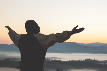 Fototapeta premium Man thank God on the mountain at sunrise in the morning,Praying for blessings from God in the morning.