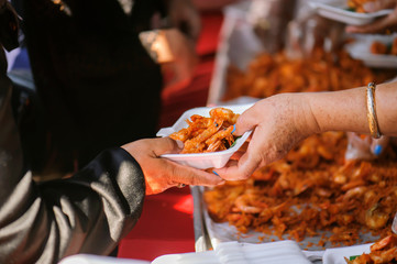 The hands of the rich are giving food to the poor and hungry.
