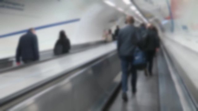 Blurred London underground commuters walking along a moving walkway (travelator)
