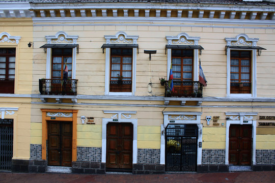 Colorfol row of windows and doors with flags on a steep hill in quito ecuador