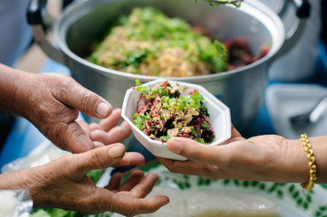 Volunteers serving charity food to the poor: the concept of hunger