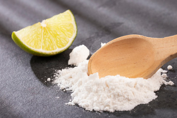 Fototapeta na wymiar Baking soda (sodium bicarbonate) and lemon - Citrus × latifolia