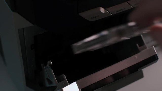 Side close up detail shot, man dj turn the page of cassette in old vintage analogue tape recorder or hifi stereo, dark low light contrast scene, 4H UHD