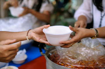 hands of the poor receive food from the donor's share. poverty concept