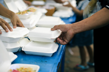 Fototapeta premium hands of the poor receive food from the donor's share. poverty concept