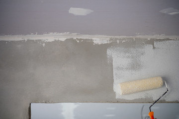 Worker with the roller painting the wall with colorful painting © Dontree