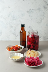 Fermented vegetables on plate on gray background: sauerkraut, pickled cabbage with beetroot, pickled cucumbers, carrots and tomatoes. Vegetarian food concept