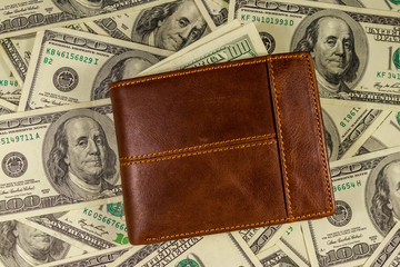 Brown leather wallet on the american one hundred dollar bills background