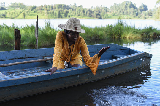 Woman with a hat playing in a boat in Kenya