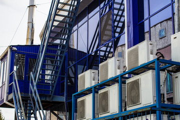 Obraz premium Wall of a large office building with blue windows and air conditioning