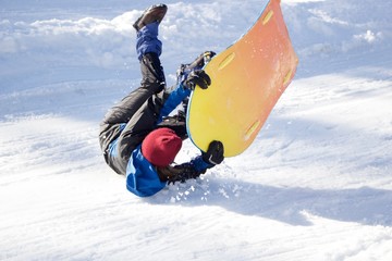 sledder rolling down the slope