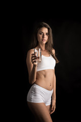 Fototapeta na wymiar Female fitness model holding a water glass
