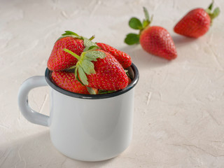 Fresh red strawberries in metal cup. Strawberry in rustic cup on oriental white background