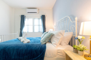 bedroom of the house or home with cozy bed , swan towel , high raised ceiling and blue blanket , interior design real estate 