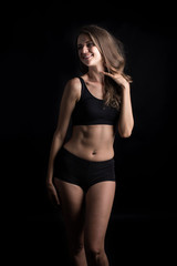 Fototapeta na wymiar Beautiful woman with healthy body on black background