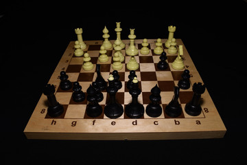Wooden chess board and black chessmen like a game background